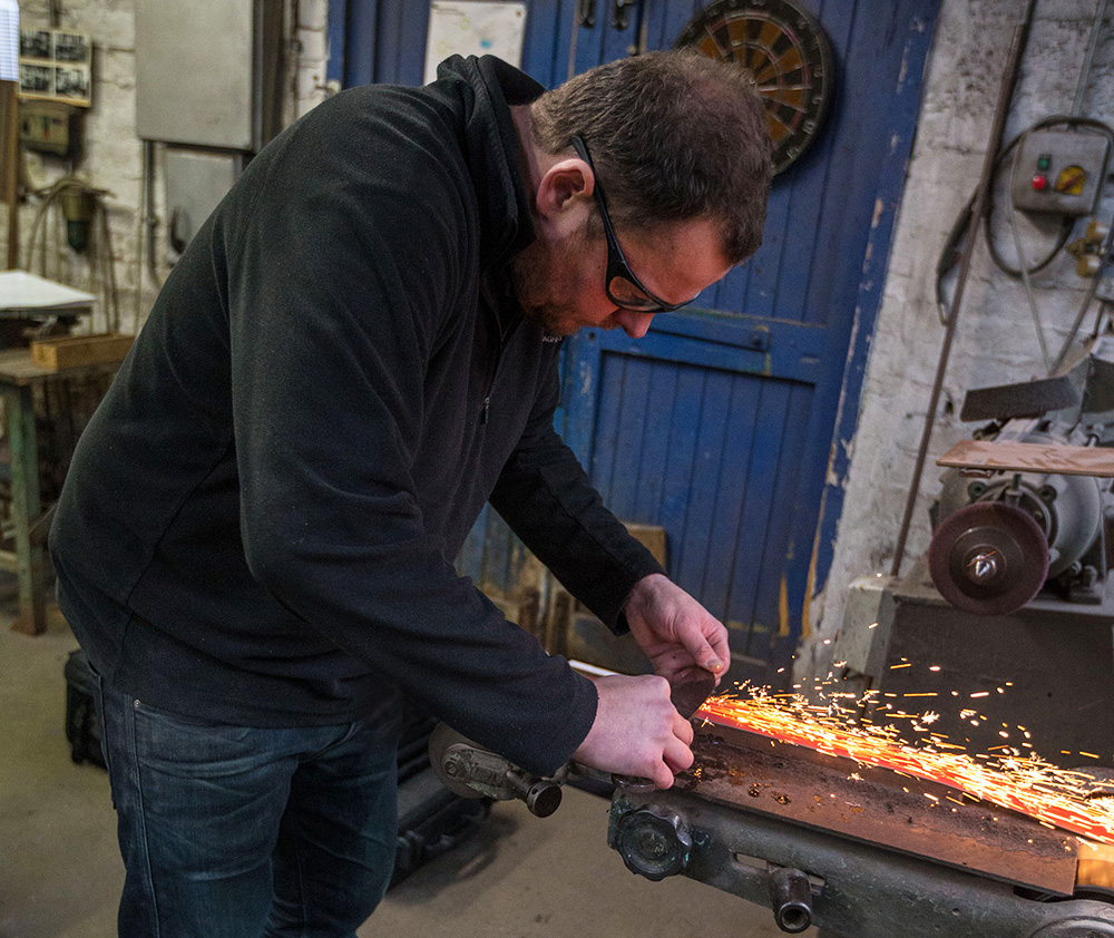 Stuart Mitchell sharpening a blade in his workshop